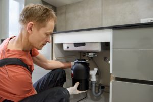 technician-fixing-garbage-disposal