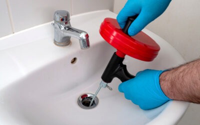 plumber using auger to snake a drain