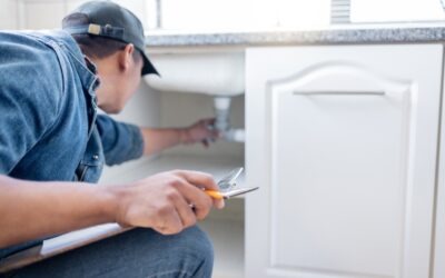 plumber working under sink