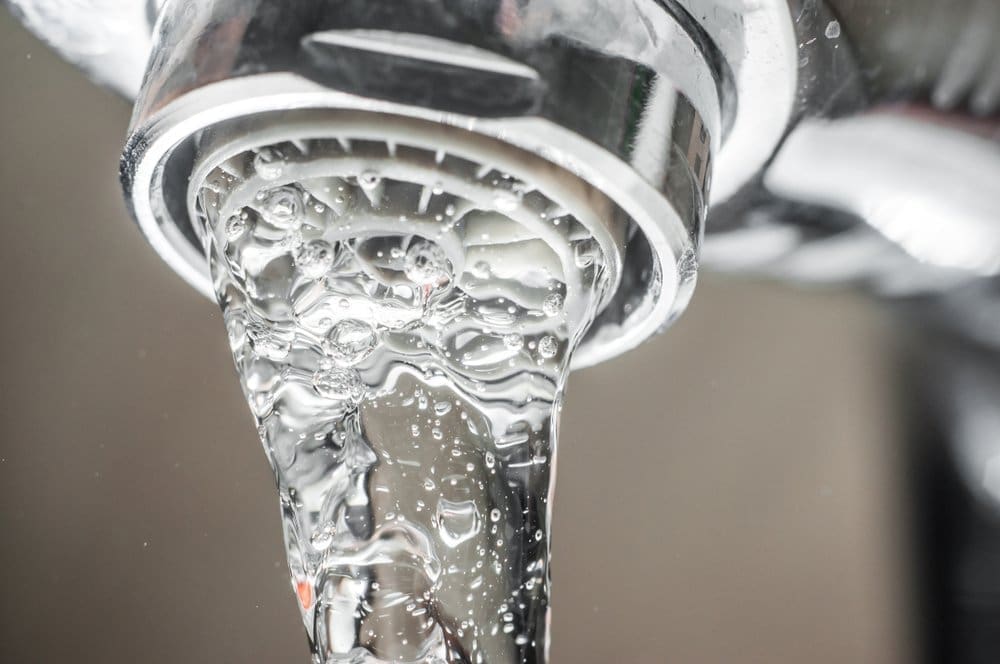 Clean filtered water flows from a modern faucet after a commercial water treatment and softener installation service in Kingman, Arizona. The image highlights purified water with visible clarity and smooth water flow that represents improved filtration and reduced hard water minerals inside residential and commercial plumbing systems. Plumbing by Jake provides commercial water treatment and softener installation in Kingman AZ with reverse osmosis systems, water filtration equipment, and hard water solutions designed for Arizona water conditions. Property owners in Kingman can contact Plumbing by Jake at 928-615-8228 for water softener installation, water purification systems, and commercial water treatment services.